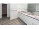 Modern bathroom with gray tile floors, double sink vanity with white cabinets and granite countertop, and a large mirror at 5496 Clearview Dr, North Charleston, SC 29420