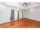 Spacious bedroom with hardwood floors, tray ceiling, fan, and a large window letting in natural light at 5496 Clearview Dr, North Charleston, SC 29420