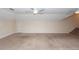 Spacious bonus room with neutral carpet, ceiling fan, and a staircase to the side at 5496 Clearview Dr, North Charleston, SC 29420
