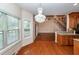Open concept dining area with hardwood floors, large windows, and decorative lighting fixture with access to living room and kitchen at 5496 Clearview Dr, North Charleston, SC 29420