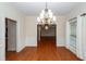 Open-concept dining room with hardwood floors, wainscoting, a chandelier, and ample natural light at 5496 Clearview Dr, North Charleston, SC 29420