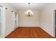 Elegant dining room featuring wainscoting, wood floors, an ornate chandelier, and natural light at 5496 Clearview Dr, North Charleston, SC 29420