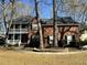Charming two-story brick home featuring a double porch and mature trees accenting the front yard at 5496 Clearview Dr, North Charleston, SC 29420