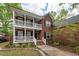 Beautiful two-story brick home showcasing a double porch with white columns and lush landscaping at 5496 Clearview Dr, North Charleston, SC 29420