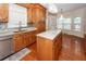 View of kitchen sink and island with granite countertops, wood cabinets, stainless appliances, and hardwood flooring at 5496 Clearview Dr, North Charleston, SC 29420
