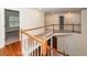 Upstairs landing with wood railing and floors offering views to the rooms below at 5496 Clearview Dr, North Charleston, SC 29420
