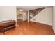 Inviting living room boasts hardwood floors, staircase, and piano at 5496 Clearview Dr, North Charleston, SC 29420