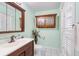 Bathroom with hardwood cabinets, white shutters, and tile floor at 5703 St Angela Dr, North Charleston, SC 29418