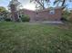 Brick home exterior view showcasing a grassy yard with mature trees and a chimney at 5937 Willard Dr, Hanahan, SC 29410