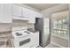 Kitchen featuring a stainless steel refrigerator, white cabinets, and a window at 621 Temple Rd # A, Ladson, SC 29456