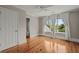 Bright bedroom features hardwood floors, ceiling fan, and a view of the neighborhood from the large windows at 642 Harbor Creek Pl # 21, Charleston, SC 29412
