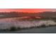 Marsh view at sunset, featuring waterways and a bright pink sky at 642 Harbor Creek Pl # 21, Charleston, SC 29412