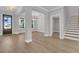 Bright living room featuring light wood floors, modern light fixtures, and an open staircase at 701 Maynard Ln, Summerville, SC 29486