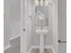 Bright powder room featuring a pedestal sink, decorative mirror, and neutral color palette at 701 Maynard Ln, Summerville, SC 29486