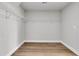 Large walk-in closet with white shelving and trim, and wood flooring for an organized and bright space at 701 Maynard Ln, Summerville, SC 29486