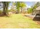 Large private backyard featuring mature trees, an outdoor patio, and lush green grass at 74 Longleaf Dr, Walterboro, SC 29488