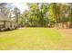 Spacious, green backyard with a wooden fence, and a large grassy area, perfect for or pets at 74 Longleaf Dr, Walterboro, SC 29488