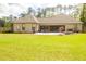 Rear exterior view of home featuring covered patio, brick facade and backyard with lush green lawn at 74 Longleaf Dr, Walterboro, SC 29488