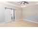 Bright primary bedroom with wood floors and a modern sliding barn door to the bathroom at 74 Longleaf Dr, Walterboro, SC 29488