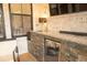 Outdoor kitchen with granite counter, mini refrigerator, sink, and television at 74 Longleaf Dr, Walterboro, SC 29488