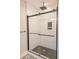 Modern bathroom featuring a black-framed glass shower with stylish black hexagon-patterned flooring and subway tile at 74 Longleaf Dr, Walterboro, SC 29488