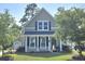 Charming two-story home featuring a classic design and a well-maintained lawn and mature trees at 7406 Purser Ln, Hanahan, SC 29410