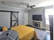 Bedroom with a barn door, TV, and window at 7406 Purser Ln, Hanahan, SC 29410