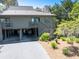 Exterior view of a two-story home with a driveway, landscaping, and a view of the surrounding trees at 754 Summerwind Cir, Edisto Island, SC 29438