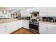 Modern kitchen featuring white cabinets, stainless steel appliances, and hardwood floors at 754 Summerwind Cir, Edisto Island, SC 29438