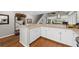 Modern kitchen featuring white cabinets, bar seating, and open access to living area with hard wood floors at 754 Summerwind Cir, Edisto Island, SC 29438