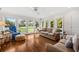 Sunlit living room with hardwood floors and large windows offering views of a well-maintained lawn at 754 Summerwind Cir, Edisto Island, SC 29438