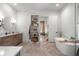A full bathroom showing a double vanity, free-standing soaking tub, and an open doorway into a bedroom at 8067 Jack Island Dr, Johns Island, SC 29455