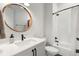Modern bathroom with a round wood-trimmed mirror, black fixtures, and tiled shower at 8067 Jack Island Dr, Johns Island, SC 29455