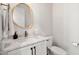 Modern powder room featuring a marble vanity, stylish mirror, and brushed gold fixtures at 8067 Jack Island Dr, Johns Island, SC 29455