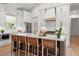 Kitchen island with white countertop, brown cabinets, seating, and stainless steel appliances in a modern style at 8067 Jack Island Dr, Johns Island, SC 29455