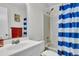 Bright bathroom featuring a shower with a blue and white striped curtain, and a well-lit vanity area at 8219 Quail Hollow Ct, North Charleston, SC 29420