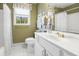 Clean bathroom with white cabinetry, tile floor, white shower curtain, and olive green paint at 8551 Pope Landing Rd, Edisto Island, SC 29438