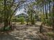 Spacious home surrounded by mature trees and landscaping, as seen from the gated driveway at 8551 Pope Landing Rd, Edisto Island, SC 29438