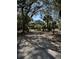 Picturesque home with lush foliage, seen through a black metal gate and driveway at 8551 Pope Landing Rd, Edisto Island, SC 29438
