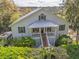 Exterior view of the home with a front porch and lush landscaping in a wooded setting at 8551 Pope Landing Rd, Edisto Island, SC 29438