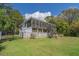Charming home exterior with a screened porch, a white picket fence, and a well-manicured lawn at 8551 Pope Landing Rd, Edisto Island, SC 29438
