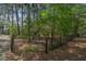 View of an iron fence surrounding lush, wooded property with mature trees and foliage at 8551 Pope Landing Rd, Edisto Island, SC 29438