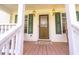 Inviting front porch with a decorative glass front door and green shutters at 8551 Pope Landing Rd, Edisto Island, SC 29438