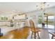 Large open kitchen featuring hardwood floors, marble table, white cabinets, and an island at 8551 Pope Landing Rd, Edisto Island, SC 29438