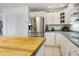 Bright kitchen featuring a butcher block island, stainless refrigerator, and white cabinets, offering ample counter space at 8551 Pope Landing Rd, Edisto Island, SC 29438