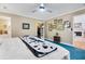 Bright main bedroom showcasing blue carpet, a ceiling fan, and a walk-in closet with an adjacent fireplace at 8551 Pope Landing Rd, Edisto Island, SC 29438