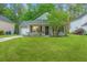 Charming single-story home with a well-manicured lawn, flowering bushes and an attached garage at 9156 Fieldstone Trce, Summerville, SC 29485