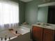 Bathtub in a modern bathroom with a vanity and a window at 9163 Parlor Dr, Ladson, SC 29456