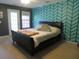 Bedroom featuring a bold patterned accent wall and a dark-frame queen bed at 9163 Parlor Dr, Ladson, SC 29456