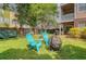 Lush backyard with Adirondack chairs, fire pit, and view of neighboring homes at 9316 Sweetbay Ct, Ladson, SC 29456